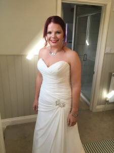 Bride standing in dress. Wedding hair and makeup. 